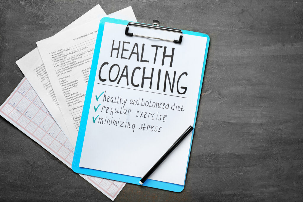 health coaching written on sheet of paper with medical documents on grey background health coaching written on sheet of paper with medical documents on grey background